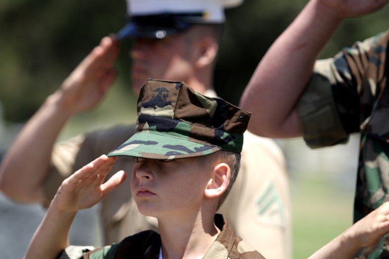 Cpl. Adams and members of the MCAS Miramar Young Marines chapter salute the colors during a Memorial Day event.